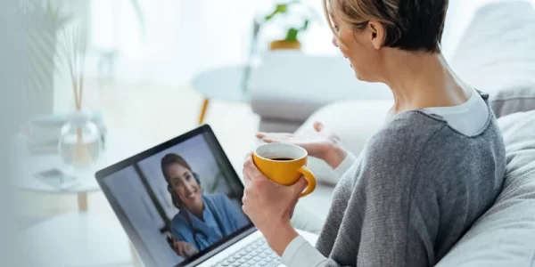 mulher-usando-laptop-e-fazendo-videochamada-com-seu-medico-enquanto-esta-sentado-em-casa.webp